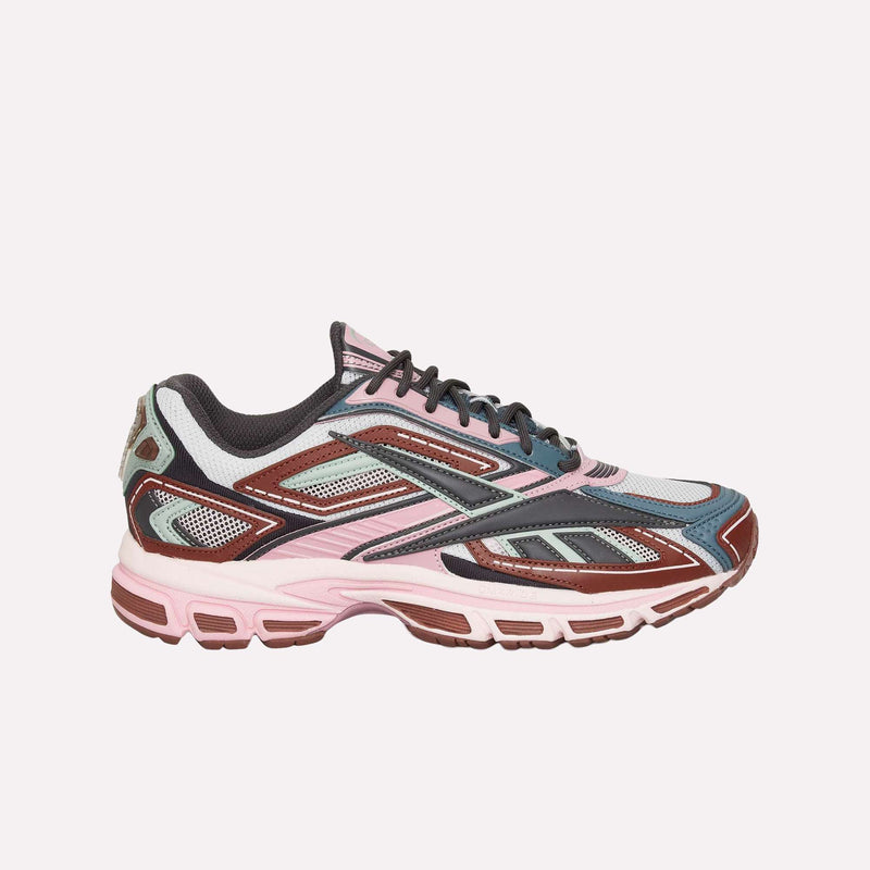 A stylish athletic running sneaker, the Reebok Premier Road Ultra LTD Shoes combine pink, maroon, gray, and black accents with mesh and synthetic overlays. Featuring a thick dual-density midsole for superior comfort and a modern layered design, these shoes exemplify Reebok’s commitment to both style and performance.
