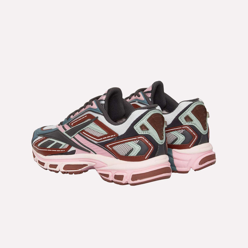 A pair of Reebok Premier Road Ultra LTD Shoes showcases vibrant shades of pink, brown, and gray, featuring mesh and synthetic overlays, chunky soles, and a supportive dual-density midsole. The running sneakers are positioned at an angle on a plain white background.