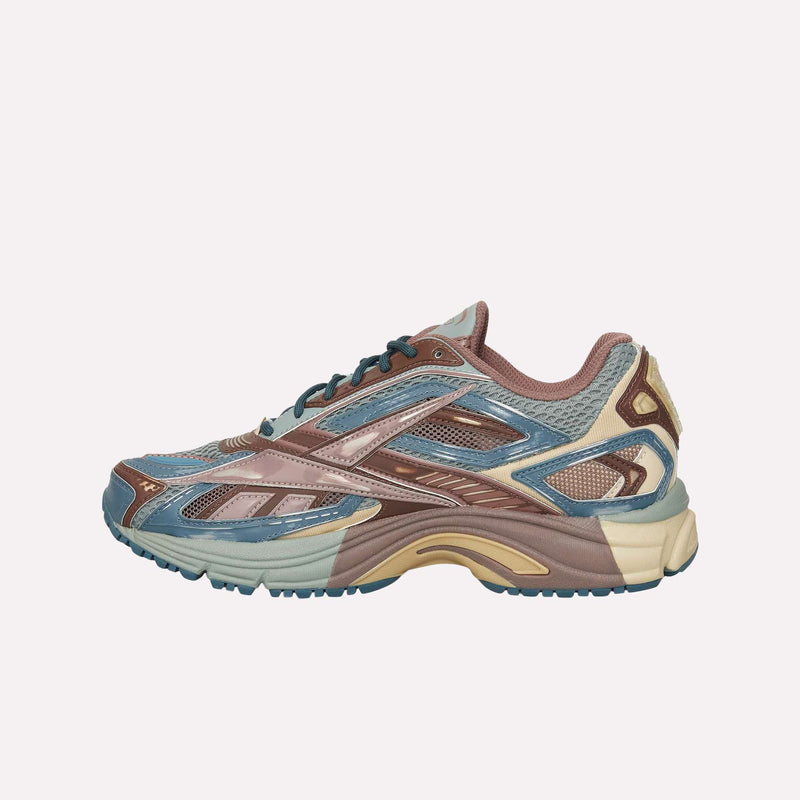 The Reebok Premier Road Ultra LTD Shoes showcase a stylish athletic design with blue, brown, and beige tones, a mesh upper, and a textured sole. Enhanced comfort is provided by the dual-density midsole—all presented in a side view against a plain white background.