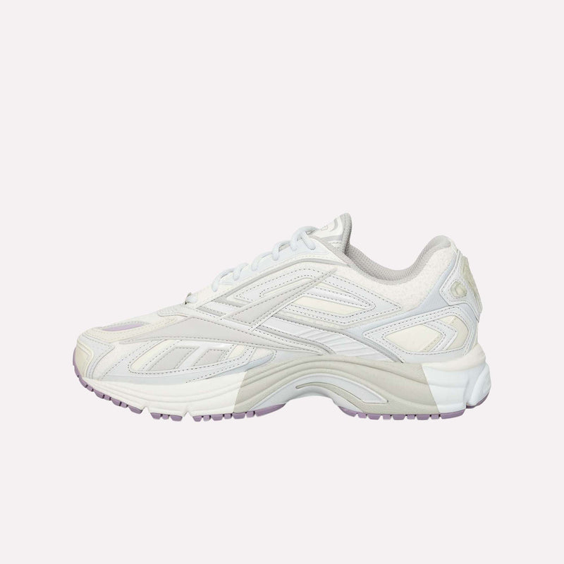 The Reebok Premier Road Ultra LTD Shoes, shown from the side against a plain light background, are white and light beige athletic sneakers with subtle lavender accents, inspired by an archival running silhouette.