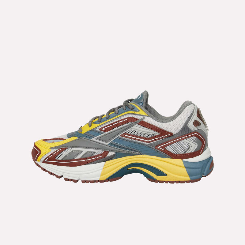 The Reebok Premier Road Ultra LTD Shoes are vibrant running sneakers featuring a mix of yellow, gray, white, blue, and brown accents. Crafted from mesh and synthetic materials with a supportive dual-density midsole, they are shown from the side against a plain white background.
