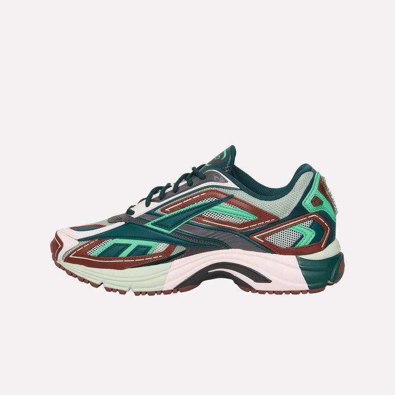 The Reebok Premier Road Ultra LTD Shoes showcase a vibrant multicolored design with green, maroon, white, and black accents. Featuring mesh panels and an intricate layered construction inspired by archival running silhouettes, these athletic sneakers are presented in a side profile against a plain backdrop. The supportive dual-density midsole adds both comfort and style to this standout model from Reebok.
