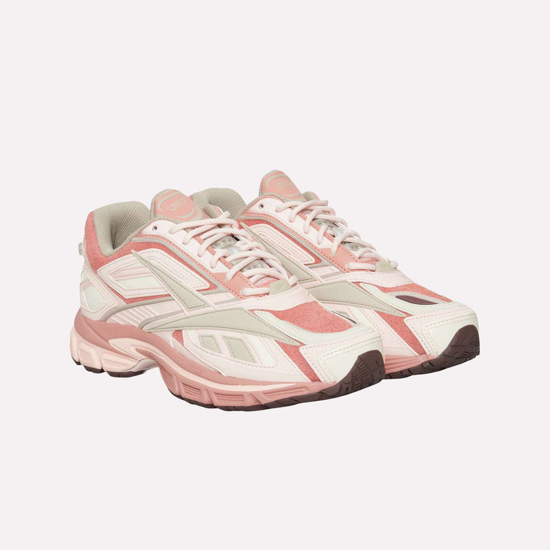 A pair of Reebok Premier Road Ultra LTD Shoes in pink and white, featuring thick soles, mesh panels, and suede accents, are displayed against a plain light background. Drawing inspiration from an archival running sneaker design, these athletic sneakers are equipped with a dual-density midsole for enhanced comfort and support.