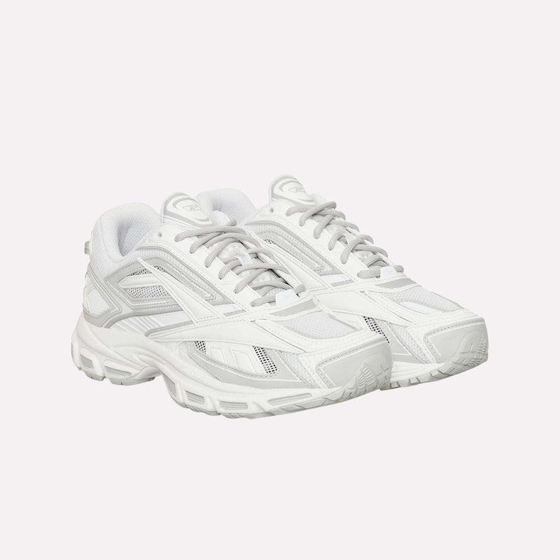 A pair of Reebok Premier Road Ultra LTD Shoes, white athletic sneakers with gray accents, mesh panels, and chunky soles inspired by an archival running silhouette, are positioned side by side on a plain white background. These sneakers feature a dual-density midsole for enhanced comfort and support.