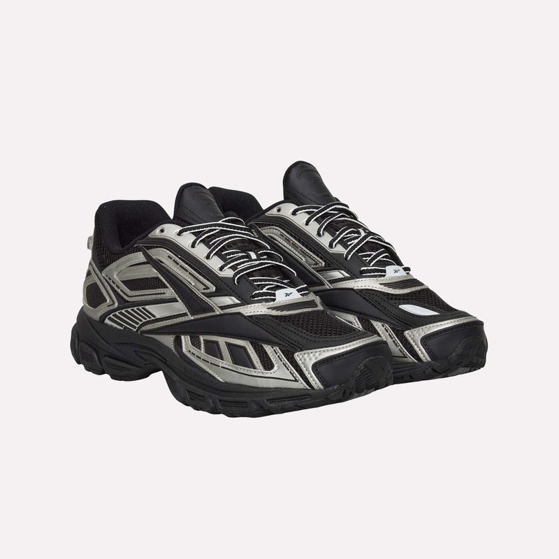 A pair of Reebok Premier Road Ultra Shoes in black and silver, featuring mesh and synthetic overlays, thick soles with a dual-density midsole, and white laces, are displayed against a plain light background.