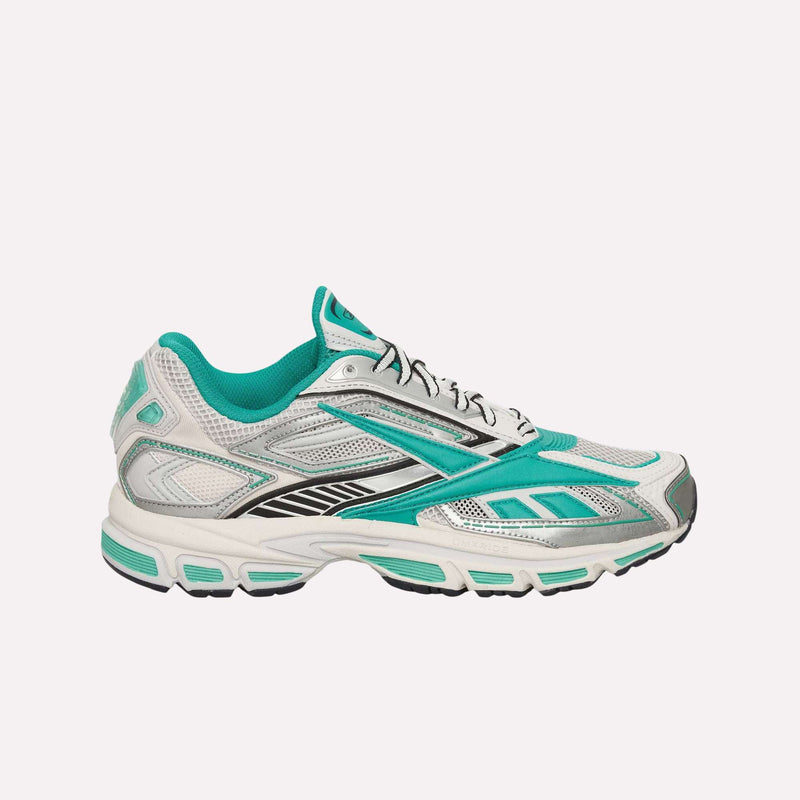 A side view of the Reebok Premier Road Ultra Shoes in white and teal showcases mesh panels, silver and black accents, and a dual-density midsole for enhanced cushioning. Presented on a plain white background, this archival running sneaker combines classic design with modern comfort.