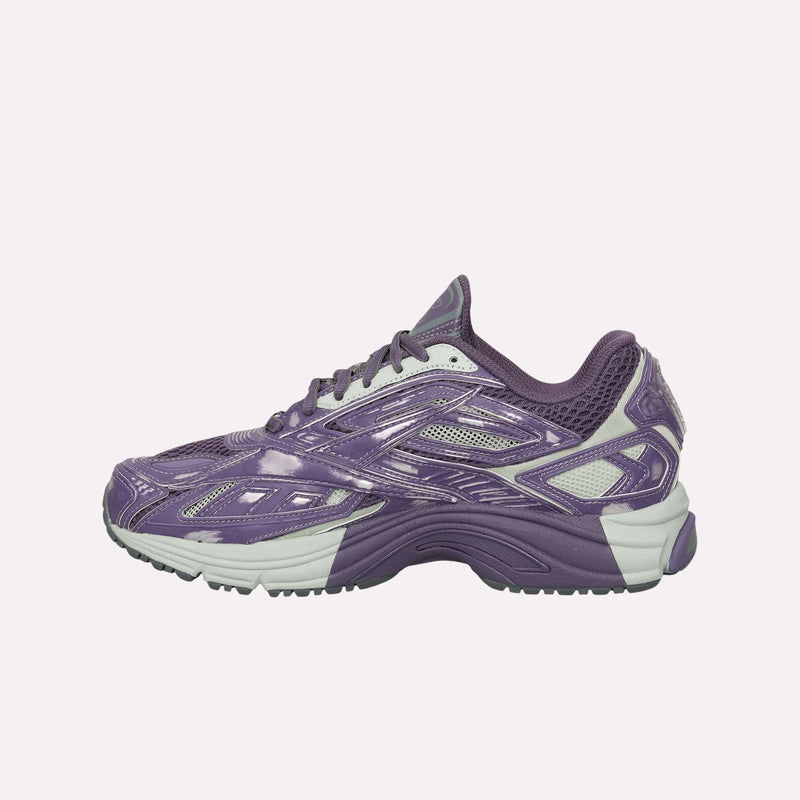 A purple and white athletic running sneaker, the Reebok Premier Road Ultra Shoes, showcases a dual-density midsole, a textured sole, mesh details, and glossy overlays. Displayed in a side profile view against a plain white background.