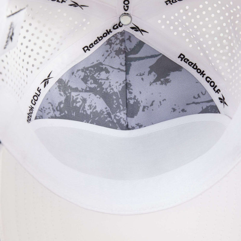 Close-up of the inside of a white Reebok Madison cap, showing mesh vents, a patterned inner lining, and a sweatband. The Reebok logo appears on the inner band.