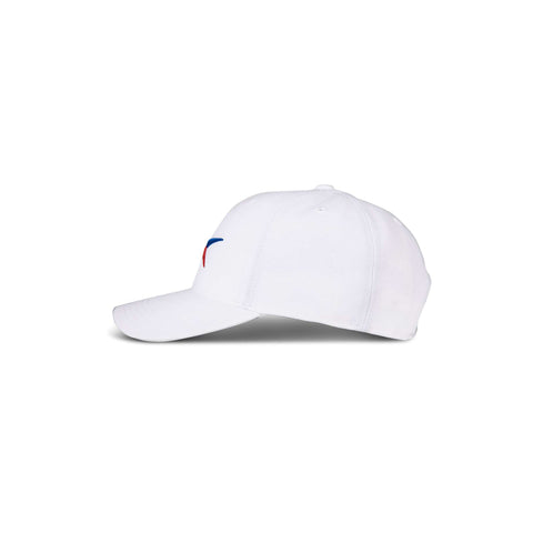 The Reebok Vector Baseball Cap is shown in white from a side view, displaying a small, curved blue and red design on the front panel and casting a faint shadow on the white background.
