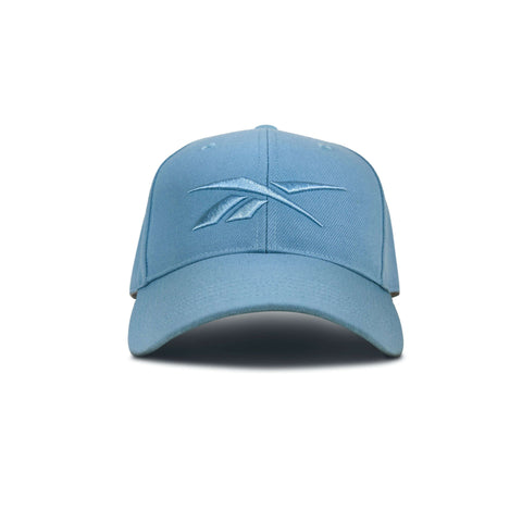 The Reebok Vector Baseball Cap is a light blue hat with a curved brim, adjustable snapback, and embroidered Reebok logo on the front, shown on a plain white background.