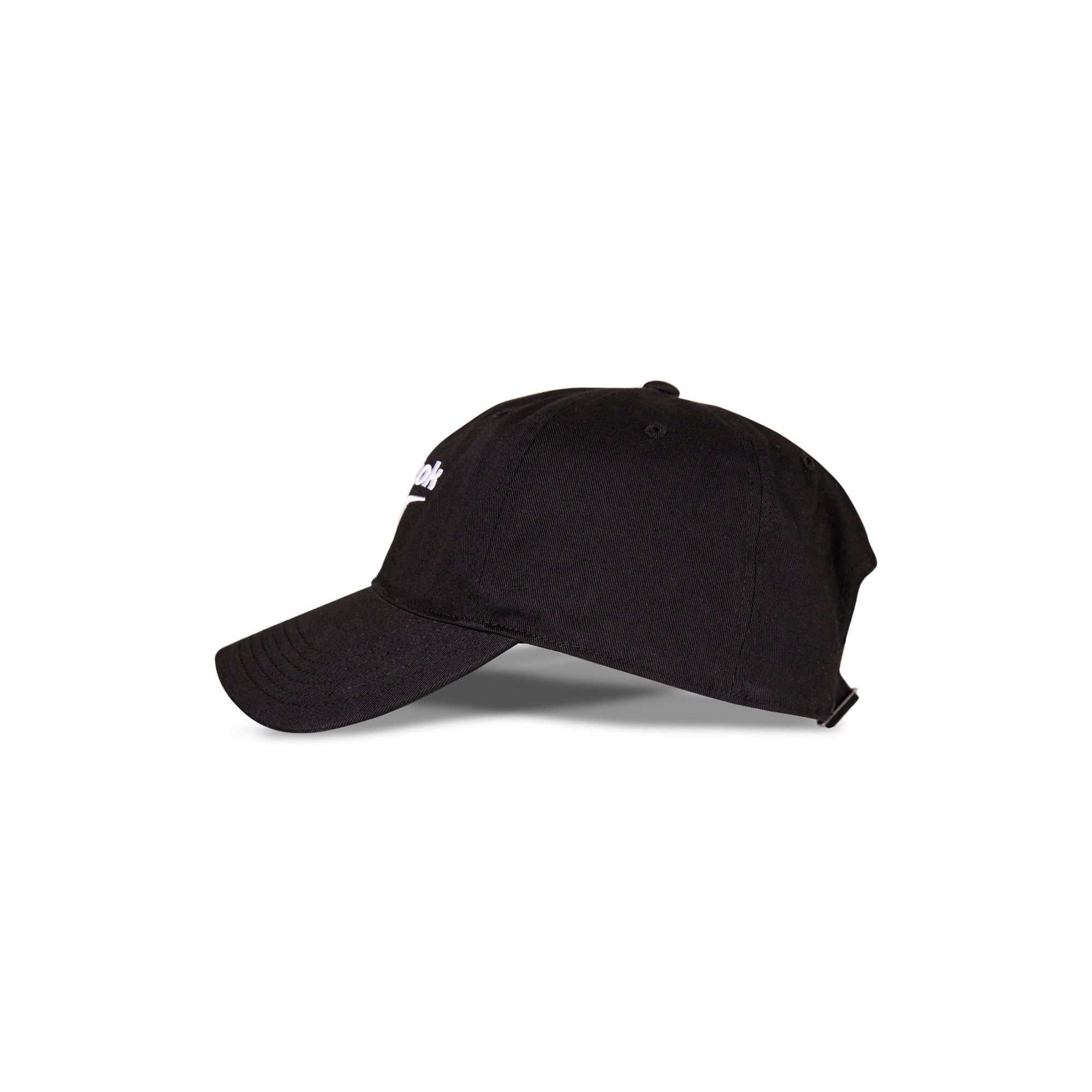 A side view of the Reebok Logo Cap in black cotton twill with a curved brim, adjustable buckle closure, and a partially visible Reebok logo on the front, placed against a white background.