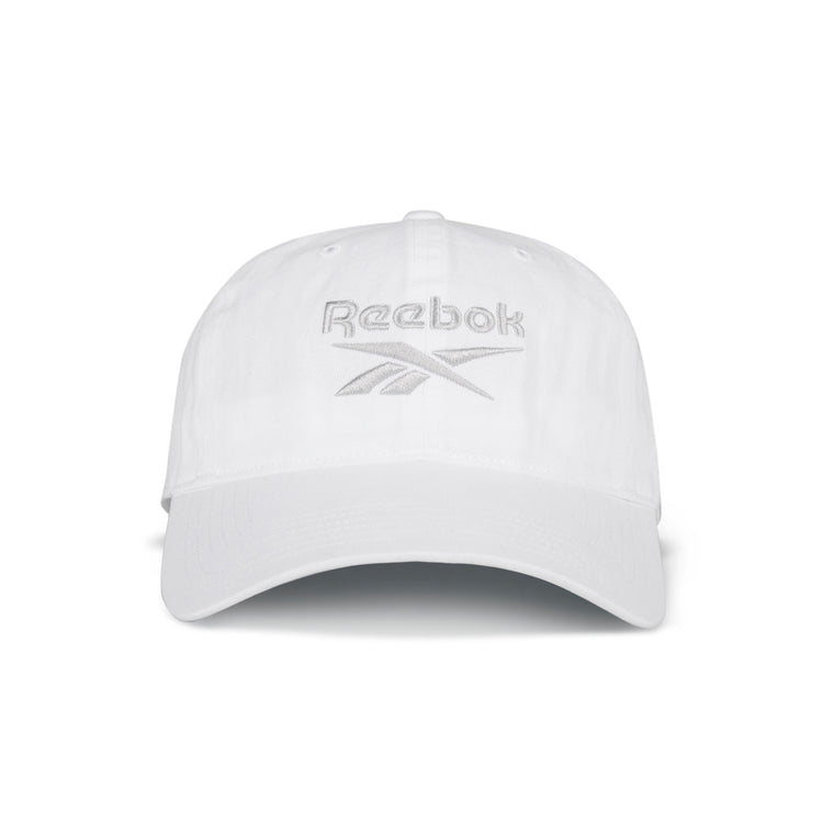 The Reebok Logo Cap is a classic white cotton twill cap with a curved brim, light gray Reebok logo embroidery on the front, and an adjustable buckle closure for a perfect fit.