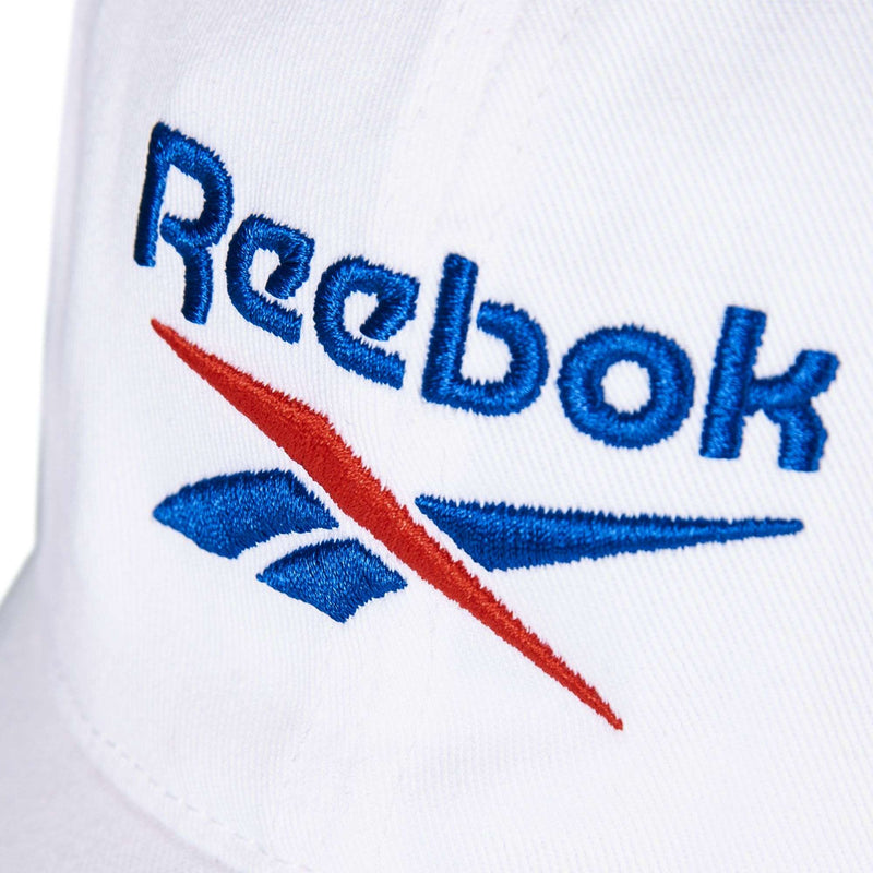 Close-up of Reebok's Logo Cap, a white fabric hat with blue and red embroidered Reebok logo and text on the front.