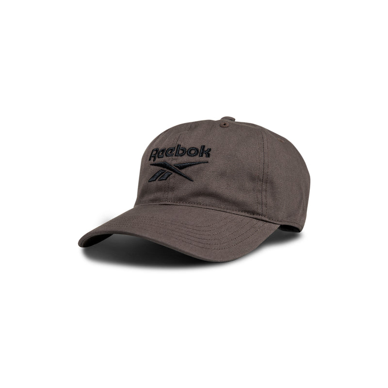 The Reebok Logo Cap is a dark gray baseball cap featuring a curved brim and black embroidered logo on the front, displayed against a white background.