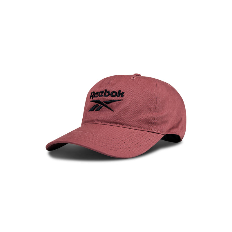 The Reebok Logo Cap is made from cotton twill in maroon, with a curved brim, black embroidered front logo, and adjustable buckle closure, displayed on a white background.