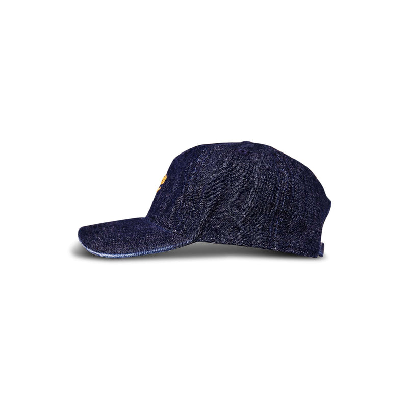 The Reebok Denim Logo Cap, shown from the side against a plain white background, features dark blue denim fabric and a curved brim.
