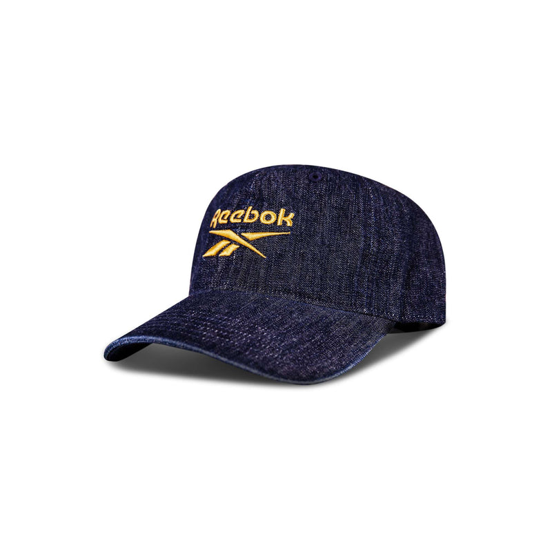 The Reebok Denim Logo Cap is a dark blue denim baseball cap with yellow embroidered Reebok logo and text on the front, shown on a white background with a subtle shadow.