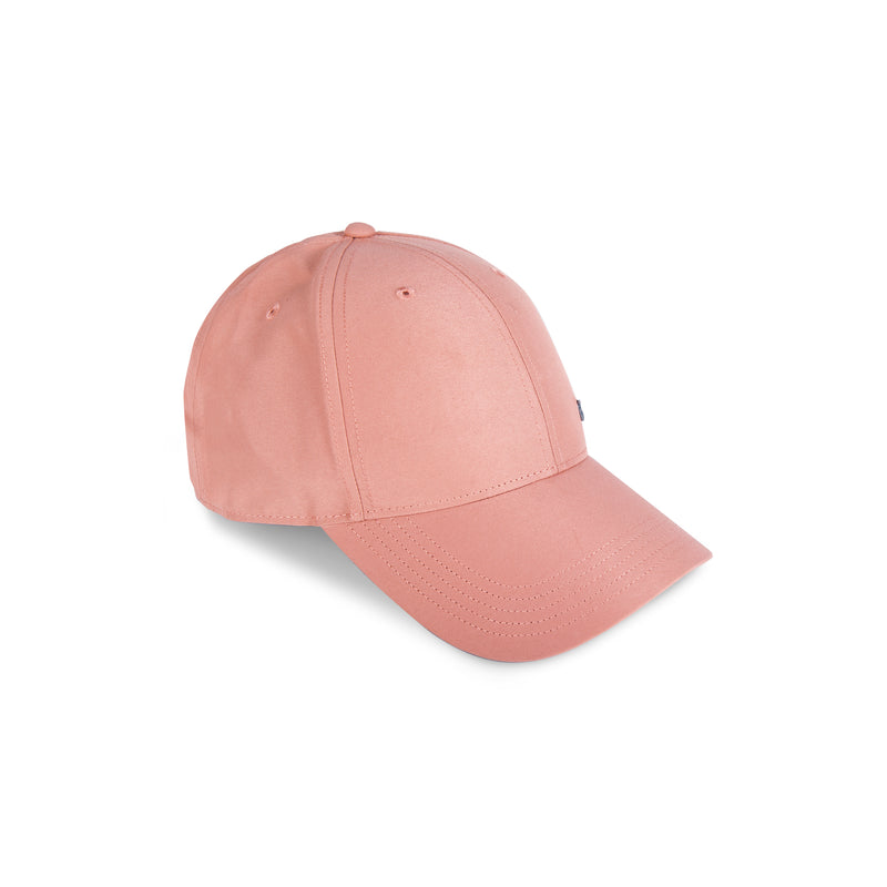 A light pink Reebok Badge Cap is shown on a white background, highlighting its front and side panels, curved brim, stitched top eyelets, and adjustable buckle for a comfortable fit.