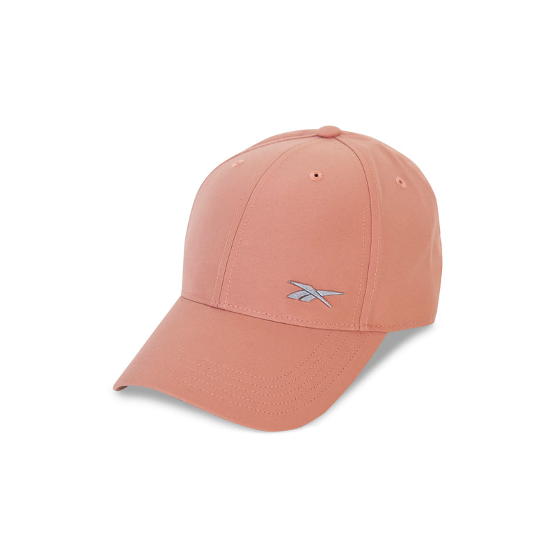 The Reebok Badge Cap in pink features a curved brim, small silver embroidered logo on the front, adjustable buckle, and moisture-wicking fabric, shown against a white background.