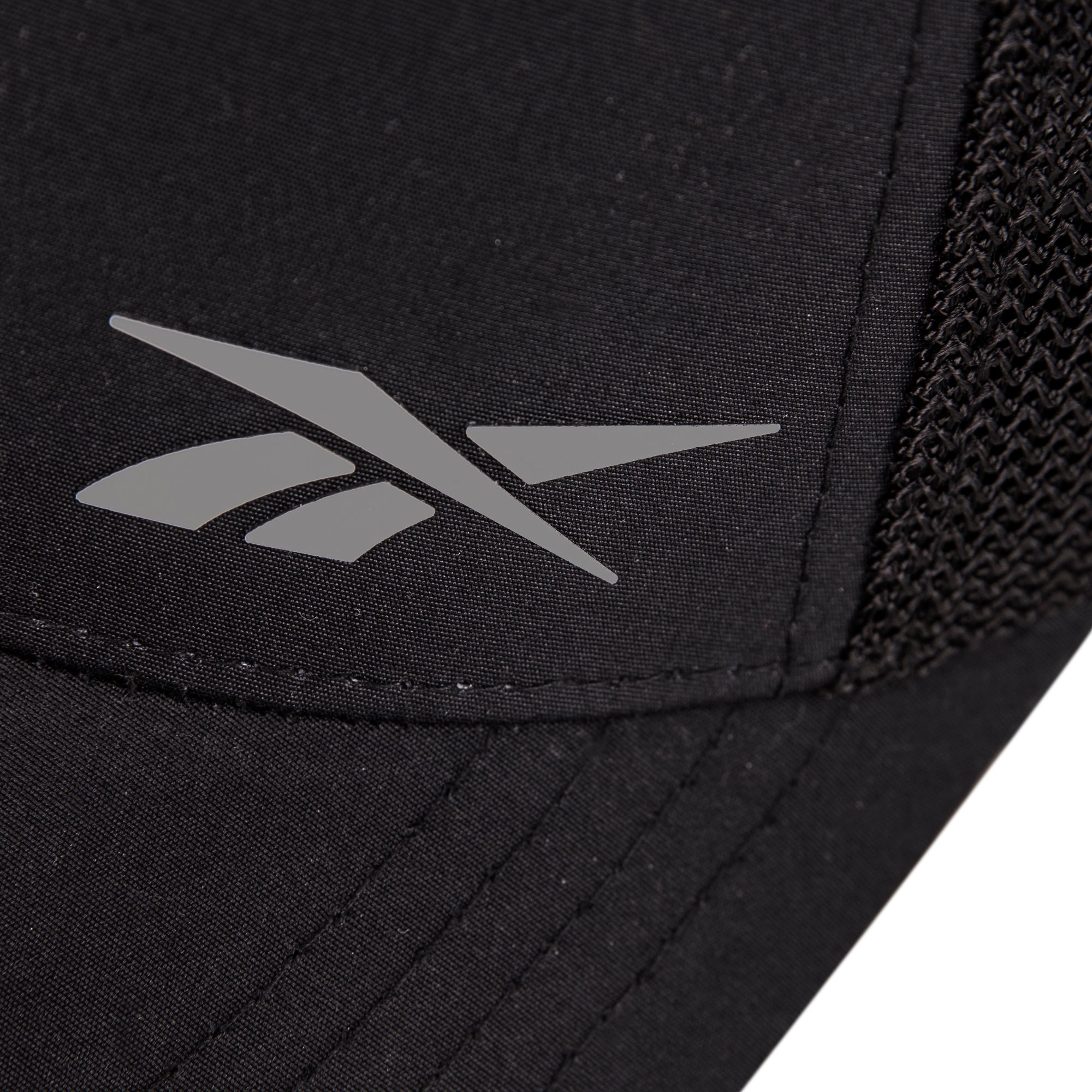 Close-up of the Reebok Athletic Cap in black, featuring a silver logo and right-side mesh detailing for comfort. Made from recycled polyester.