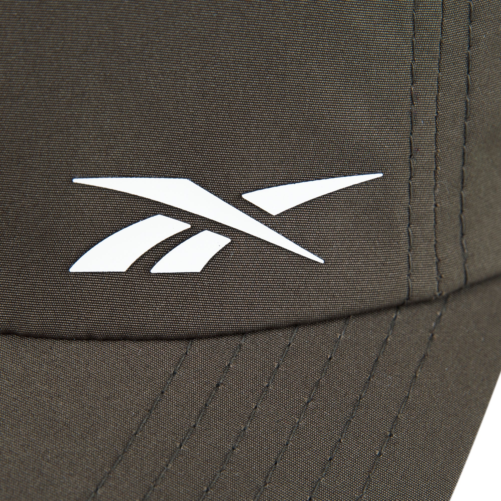 Close-up of the Reebok Flow Cap in brown, crafted from recycled polyester with a white Reebok logo, visible stitching, and a moisture-wicking sweatband for comfort.