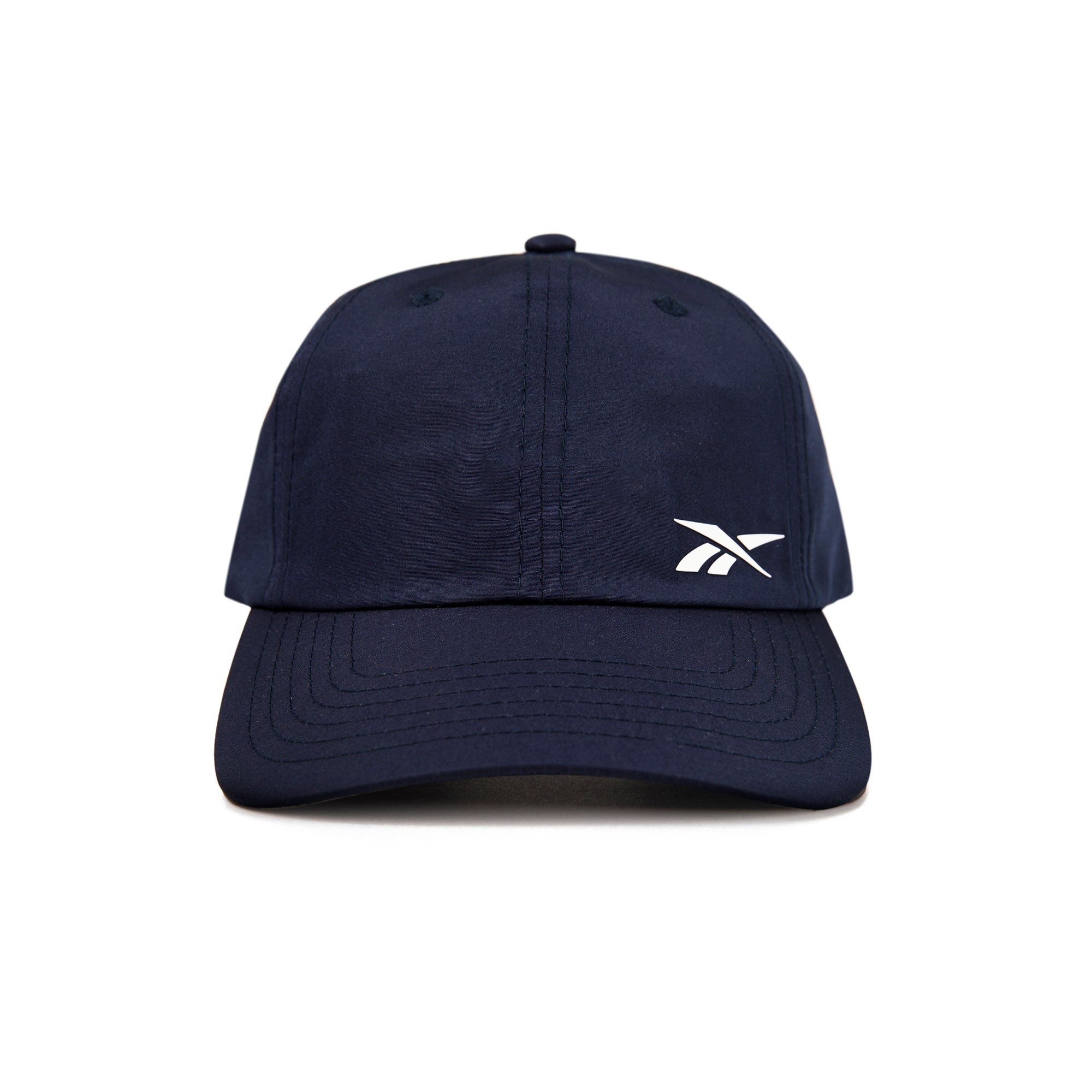 A front view of the Reebok Flow Cap in navy blue, featuring a small white Reebok logo on the left crown and a moisture-wicking sweatband for comfort.