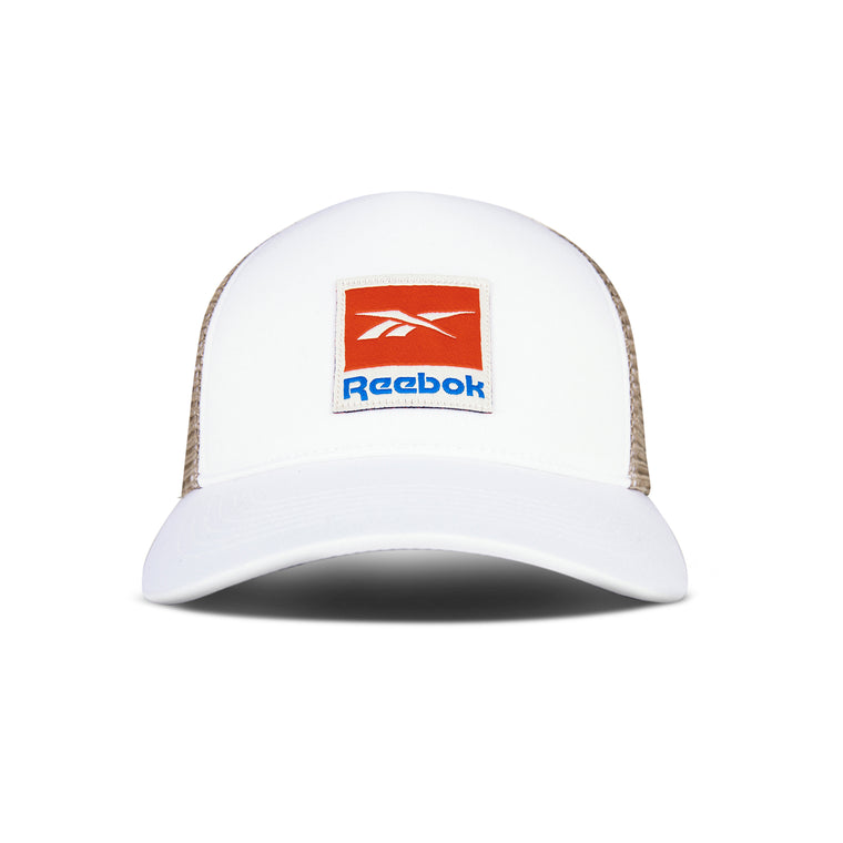 The Reebok Vintage Trucker Cap highlights athletic style with a white front, tan mesh back, snapback closure, and bold red-blue logo patch—all shown from the front on a white background.