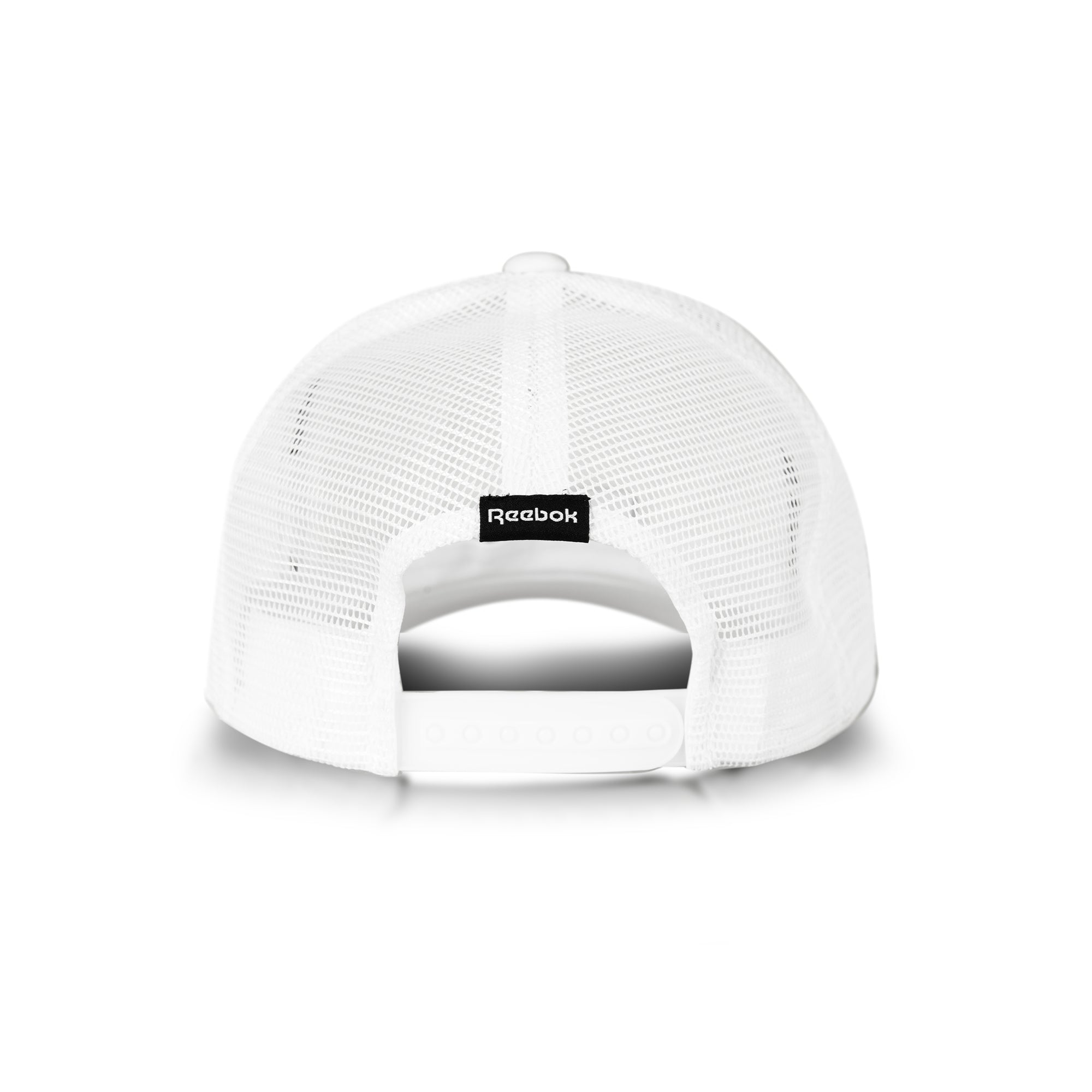 A white Reebok Deluxe Aero Cap trucker hat seen from the back, with breathable mesh, an adjustable snap closure, and a small black Reebok logo tag above the opening.