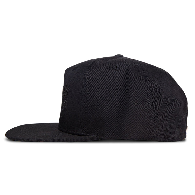A stylish black Reebok Double Vision Cap is displayed from the side on a white background, featuring a structured crown and visible stitching. The adjustable snapback and street style design are highlighted, though the front logo remains unseen.
