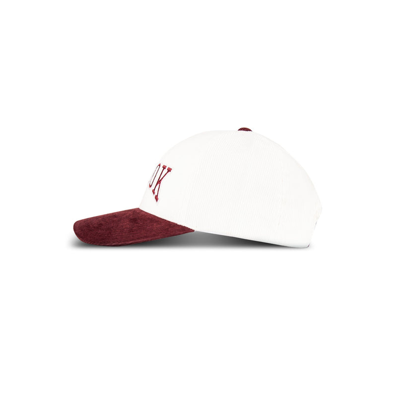 The Reebok Corduroy Gameday Cap is a white baseball cap with a maroon cotton corduroy brim and maroon embroidered side lettering, shown in profile against a white background.