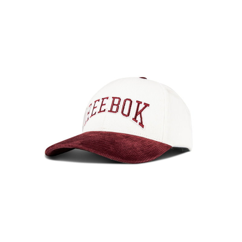 The Reebok Corduroy Gameday Cap features a white cotton corduroy crown, maroon brim, and maroon REEBOK embroidery on the front, shown against a white background.