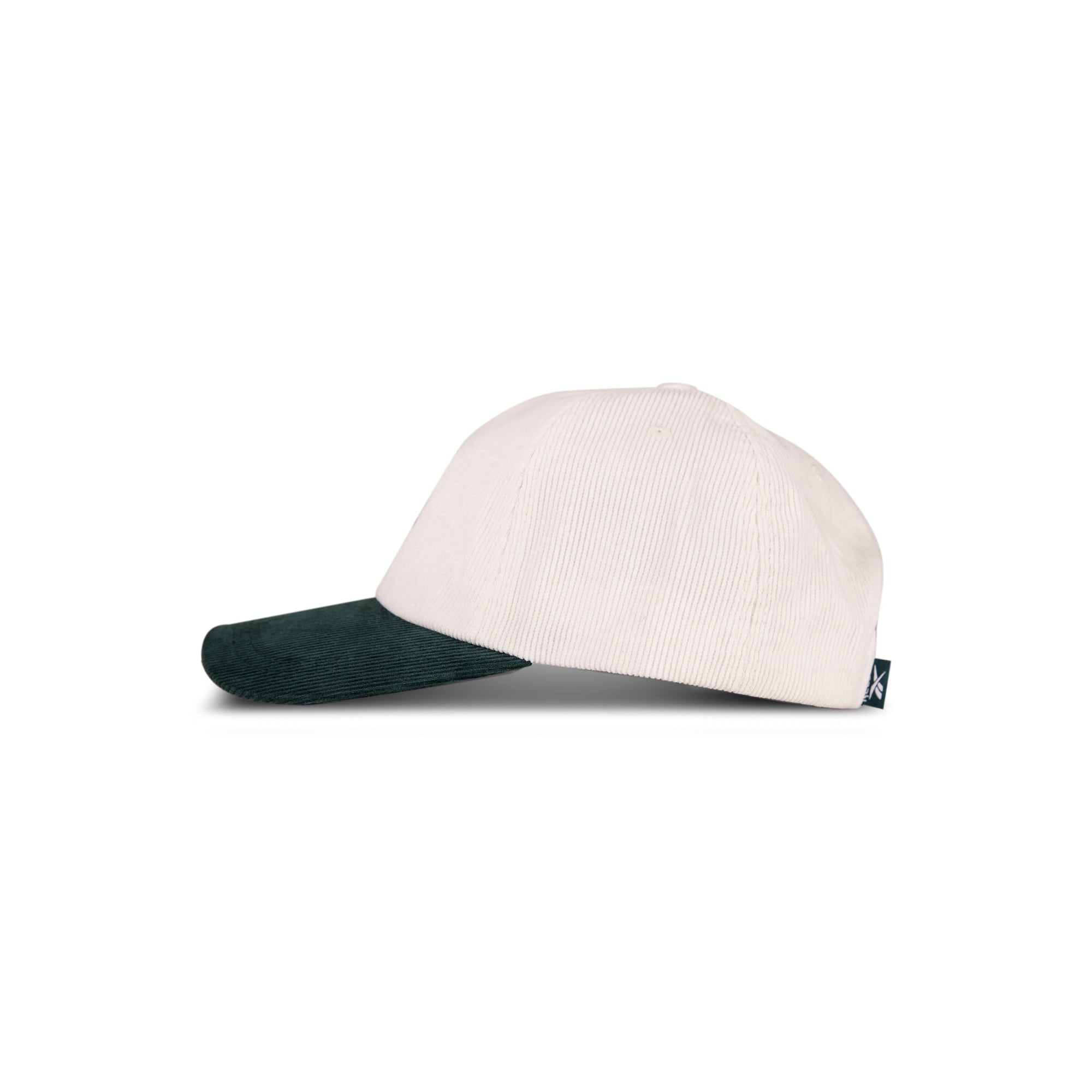 The Reebok Logo Corduroy Cap features a cream crown, dark green brim, and adjustable snapback, shown in profile against a white background.