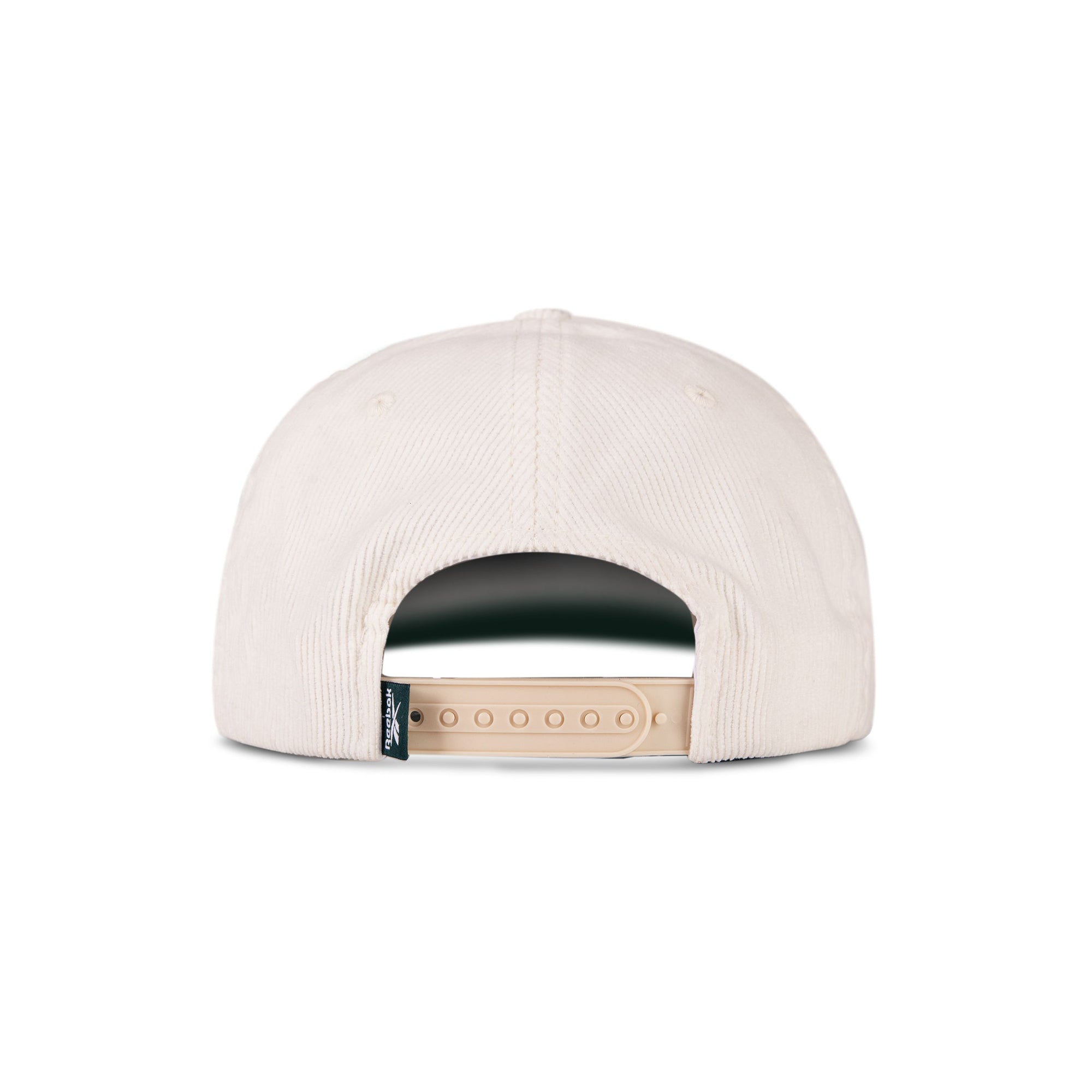 A Reebok Logo Corduroy Cap in beige is shown from the back, highlighting its adjustable snapback strap and a small black fabric tag on the left side of the opening.