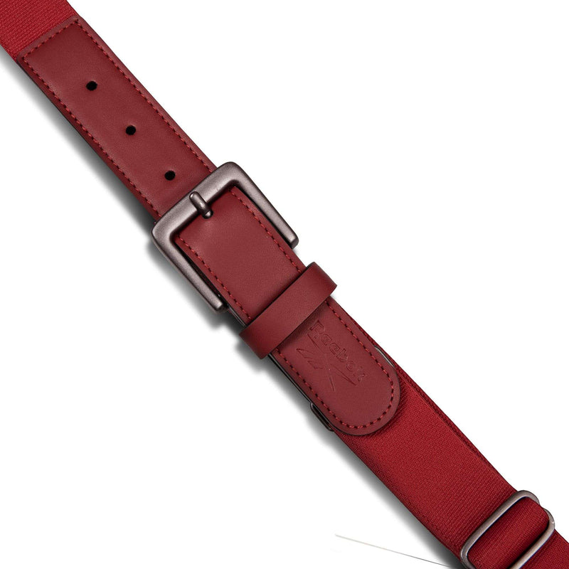 A close-up of the Reebok Youth Baseball Belt, featuring red stretch elastic material, a matte metal buckle, adjustment holes, and a stitched keeper loop, set against a white background.