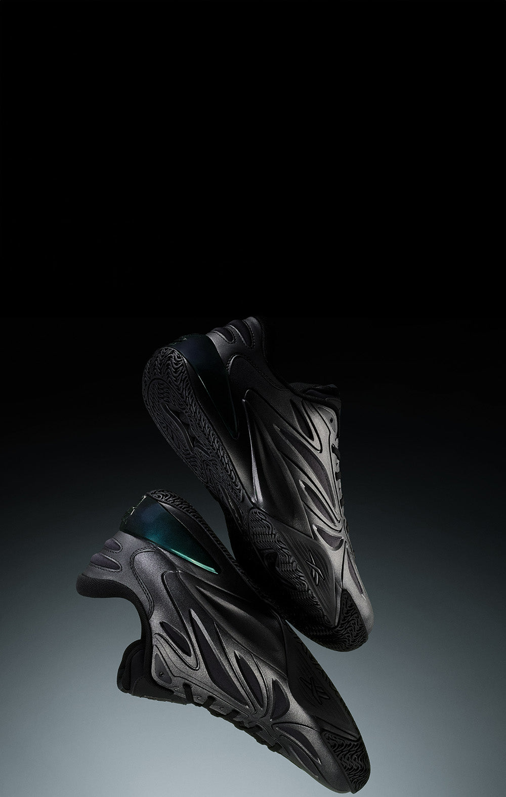 Black athletic shoes on a gradient black to gray background