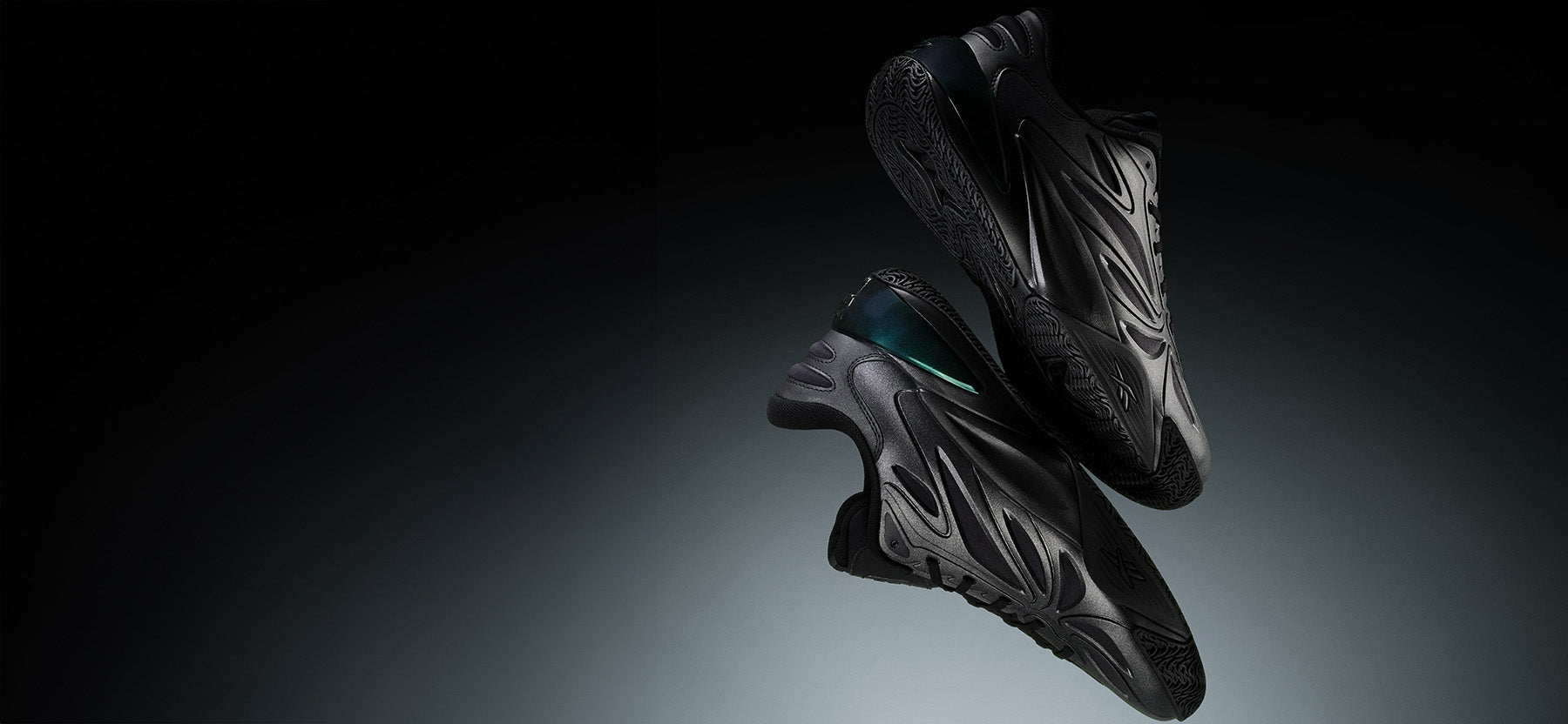 Black athletic shoes on a reflective surface with a dark background