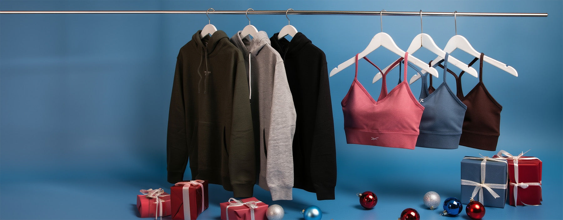 Clothing items on hangers with small gift boxes against a blue background