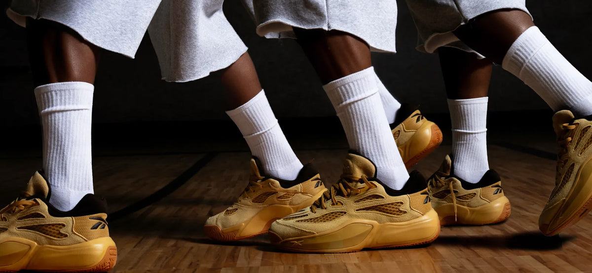 men with tan reebok on a basketball court 