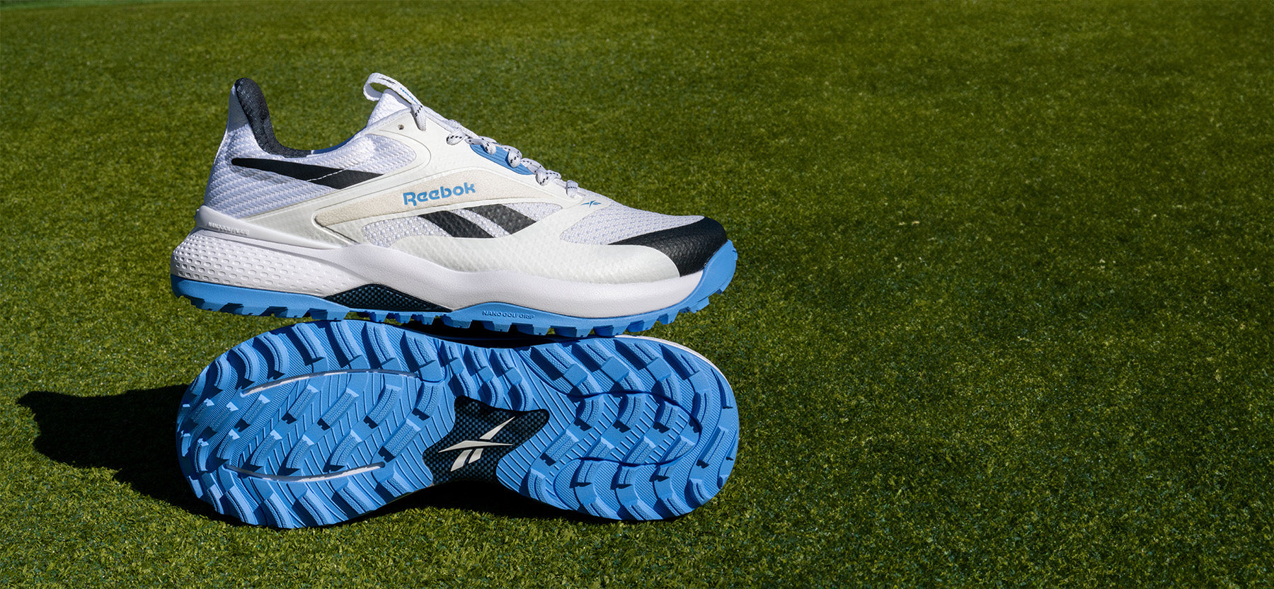 White and blue Reebok running shoes on grass