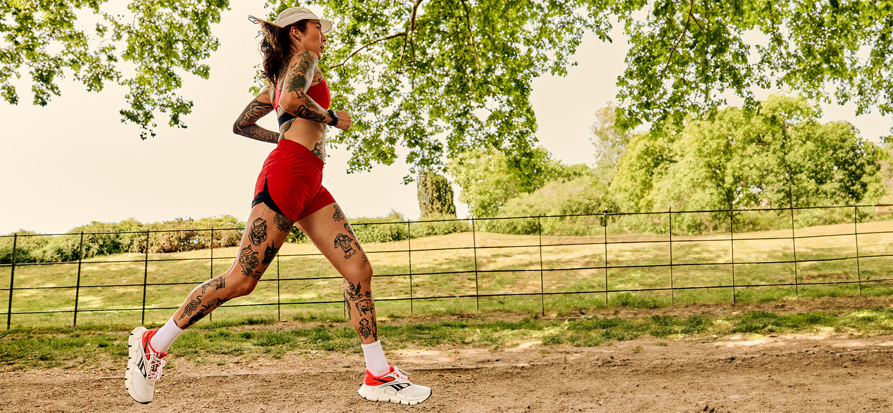 women in red running under trees