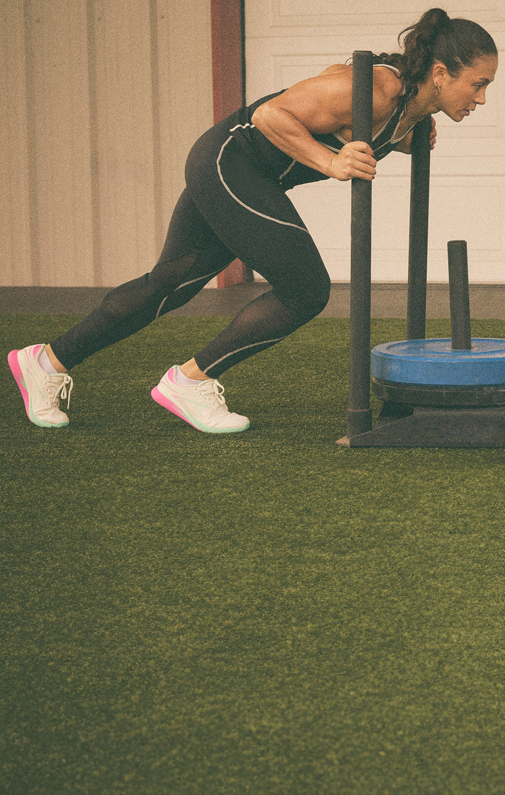 Woman exercising with a resistance band on a grassy area.