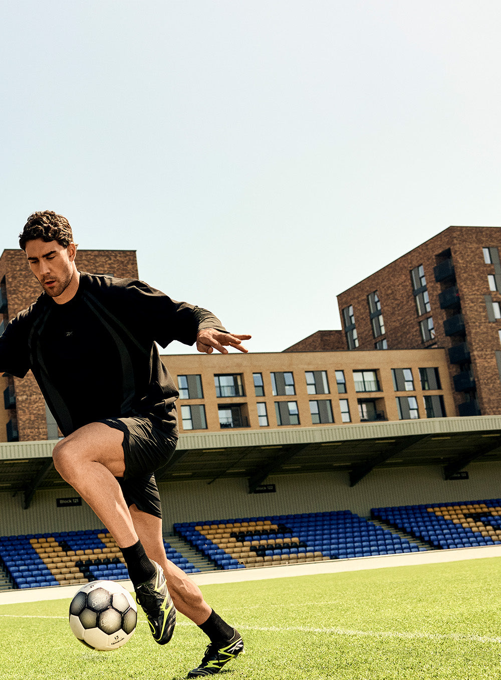 man playing soccer in a empty stadium 