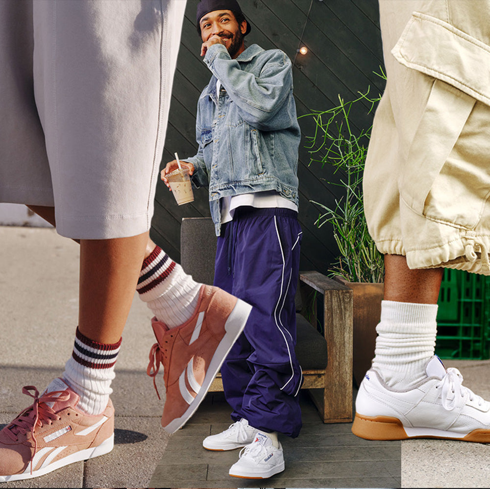 People wearing sneakers and colorful socks on a sidewalk with a casual urban setting.