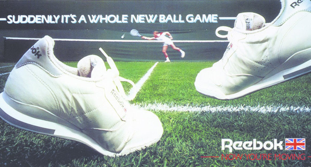 white reebok tennis shoes on green court