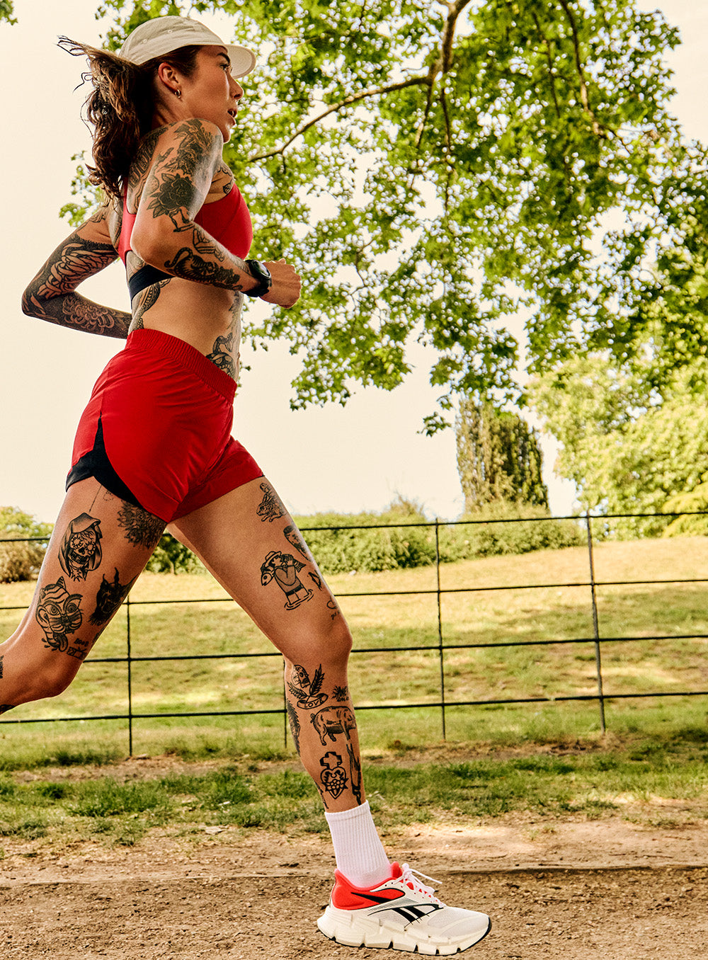 women in red running under trees