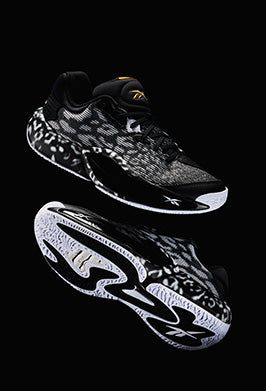 Black and white sneaker with reflective design on a black background