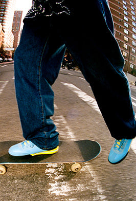Person skateboarding on a city street with buildings in the background