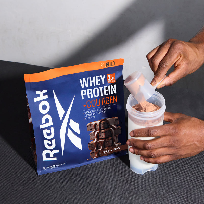 Hands holding a scoop of Reebok ReeBuild Whey Protein + Collagen over a shaker bottle, next to a pouch of collagen peptides.