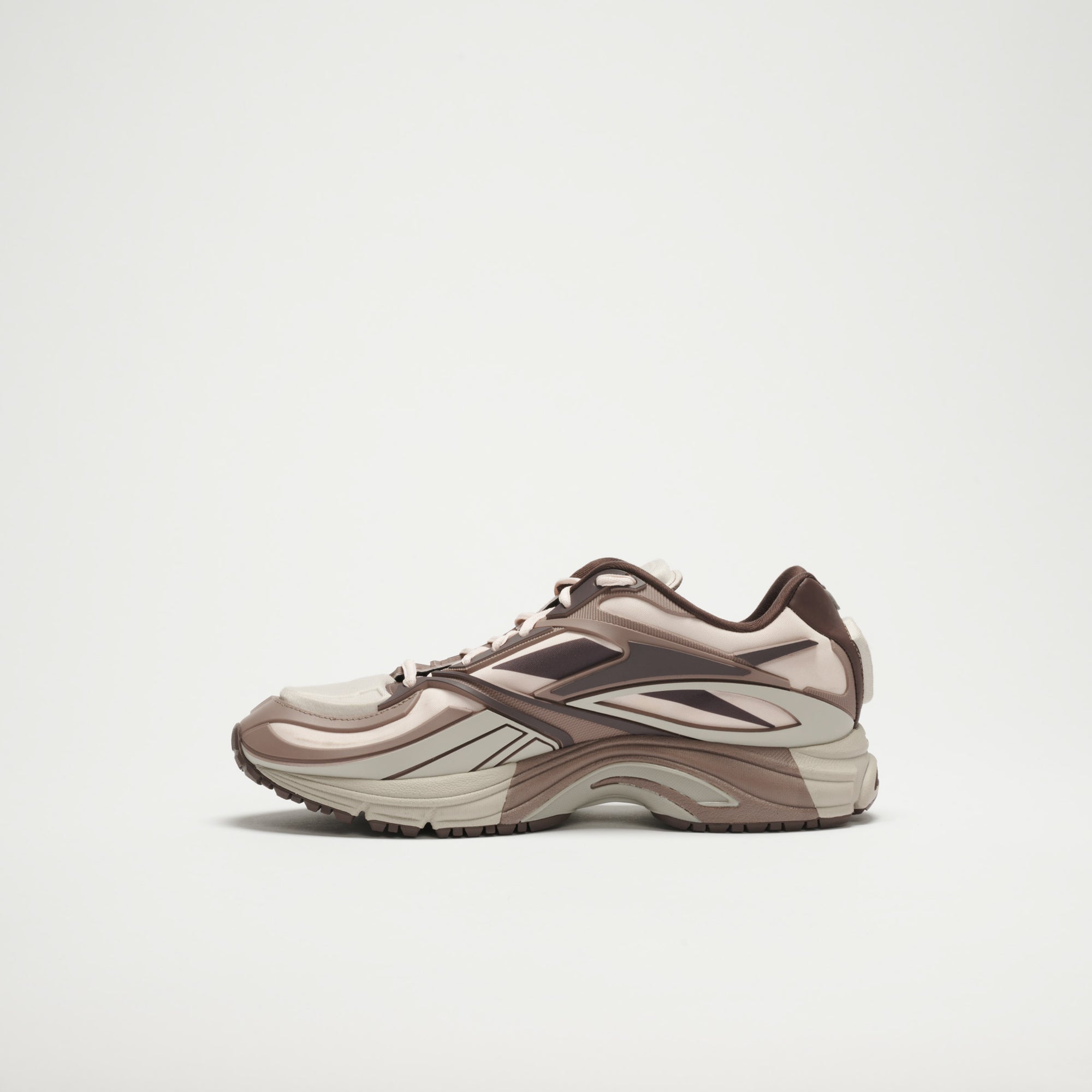 The Reebok Premier Road Modern LTD Shoes are shown in profile against a white background, featuring a beige and brown color scheme, layered panels, a chunky sole, and a modern sporty design.
