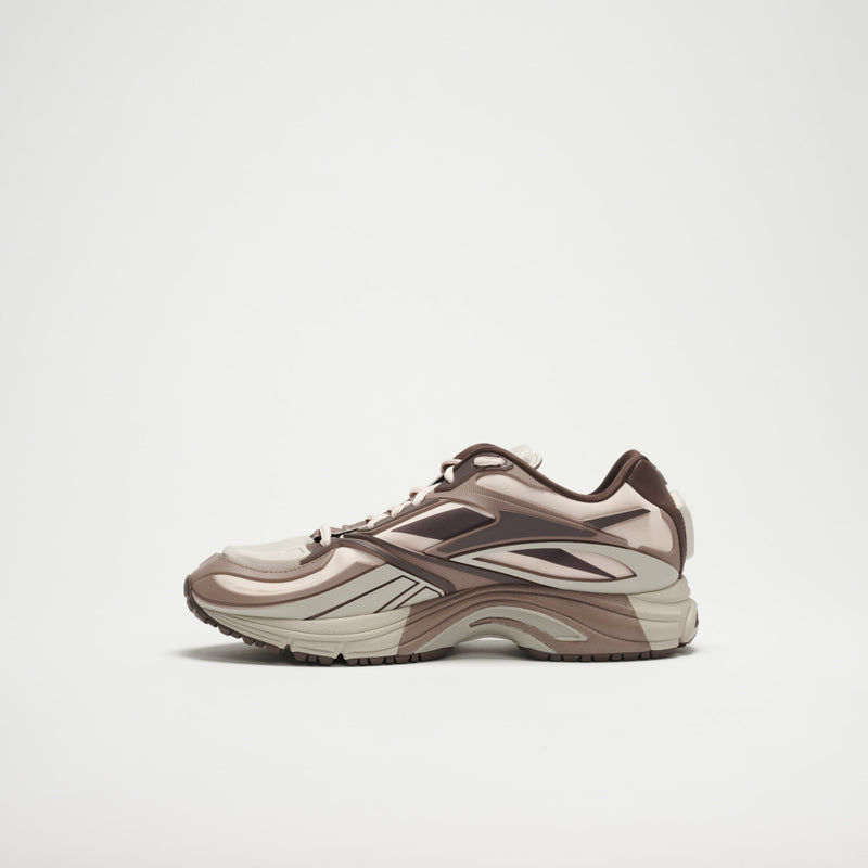The Reebok Premier Road Modern LTD Shoes are shown in profile against a white background, featuring a beige and brown color scheme, layered panels, a chunky sole, and a modern sporty design.